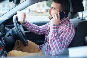 Driver on phone with coffee cup